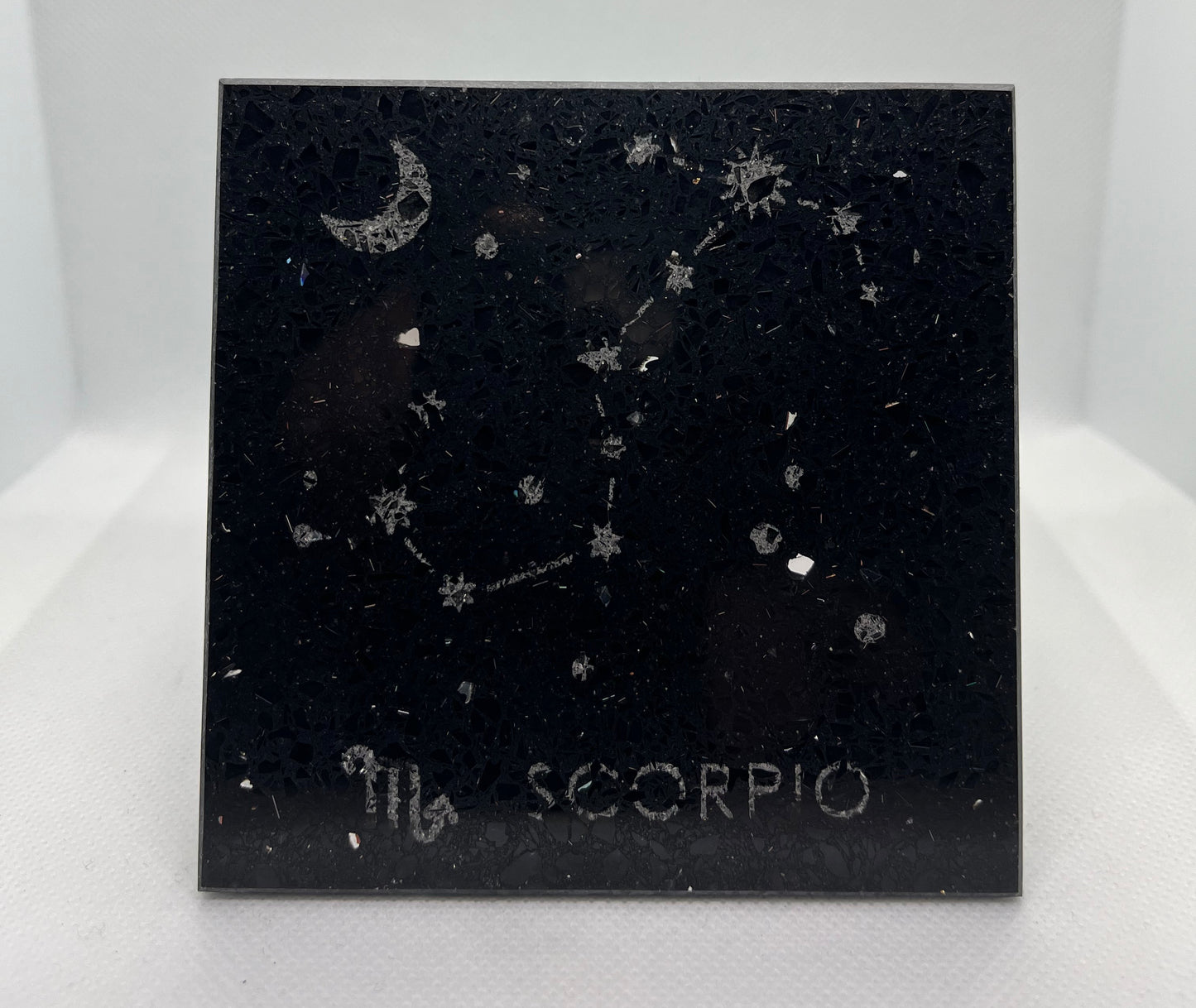 Black square coaster with Scorpio zodiac constellation design on a white background
