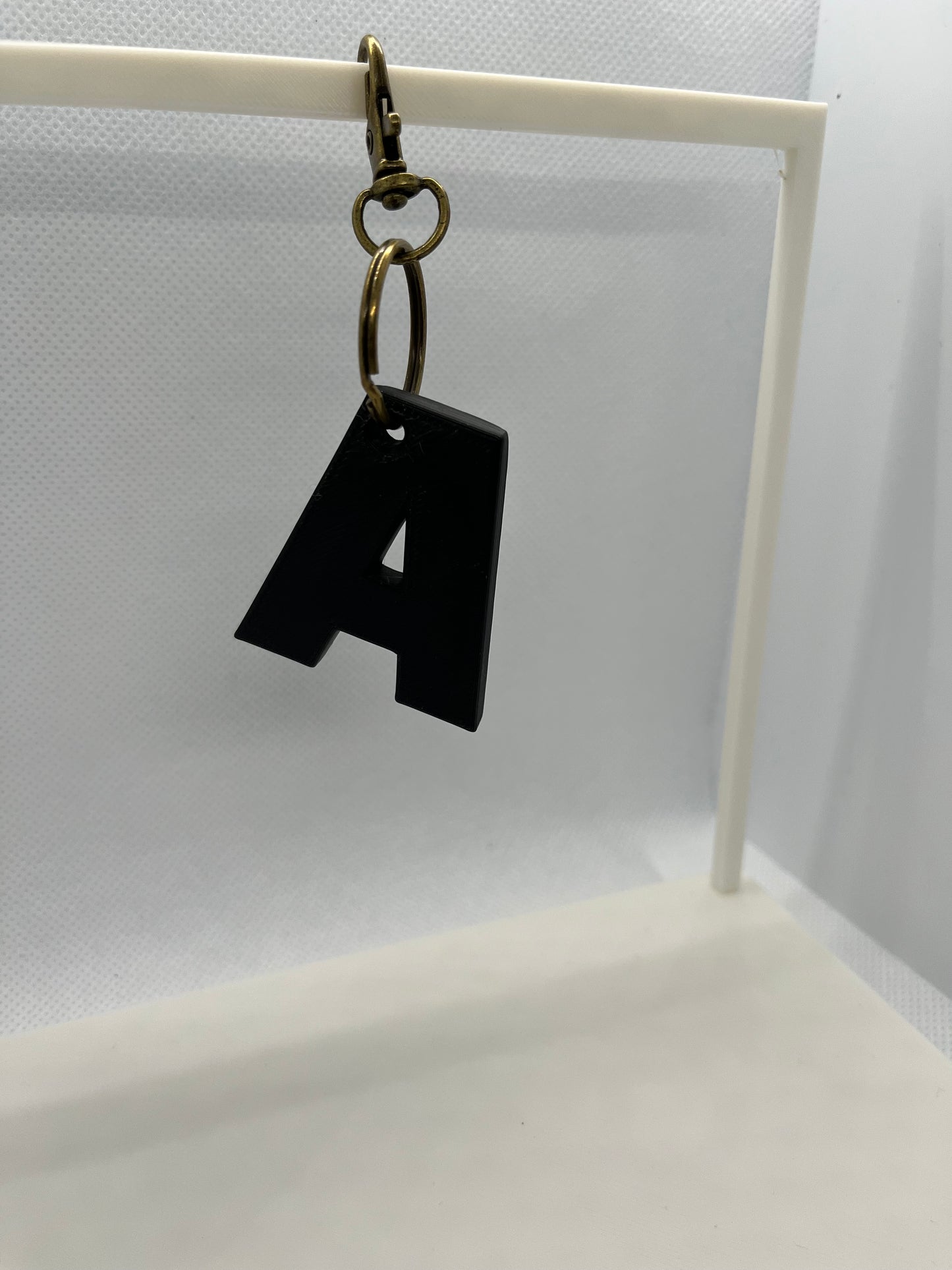Black keychain with a gold ring on a white background