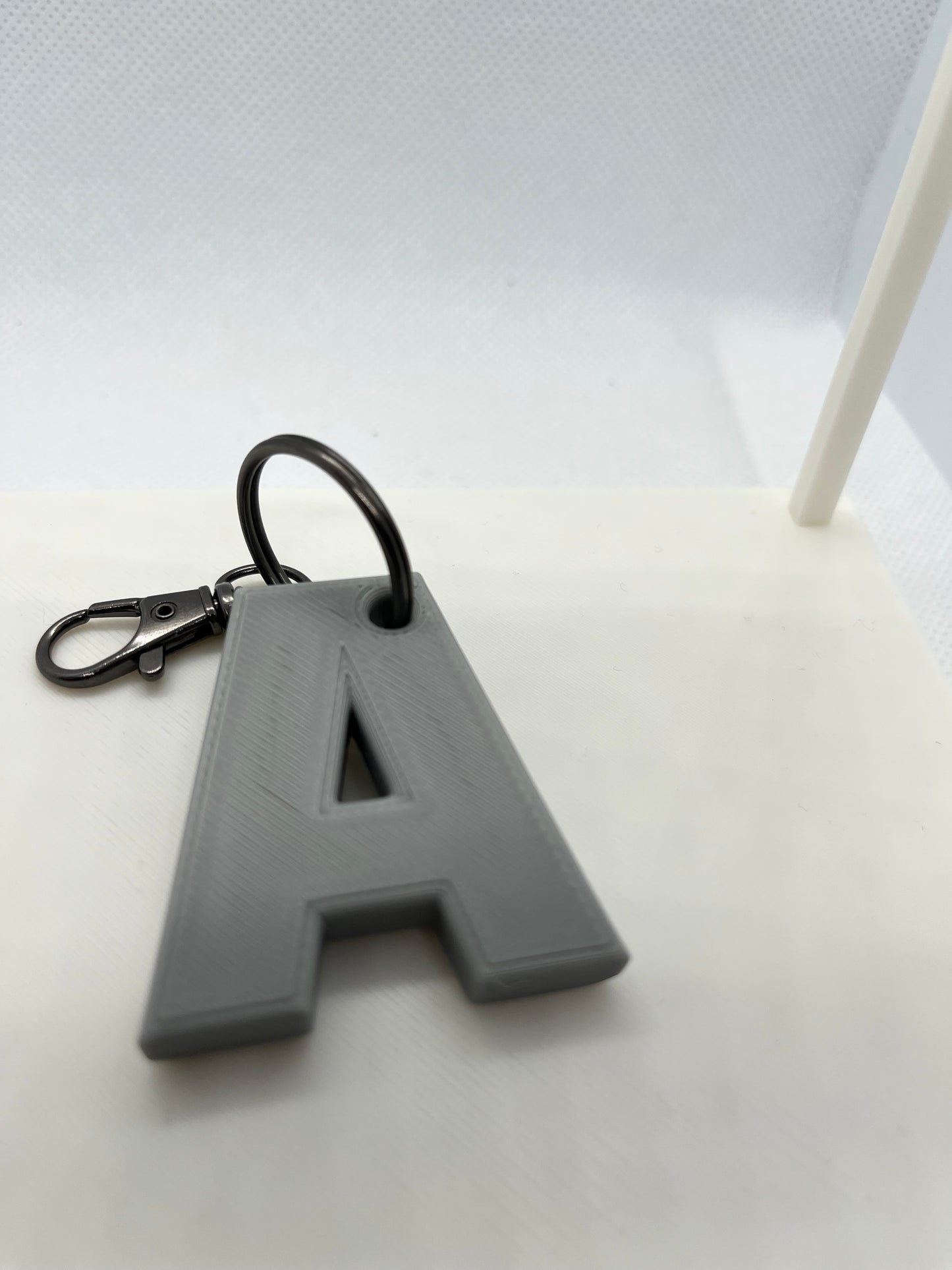 Gray letter 'A' keychain on a white background