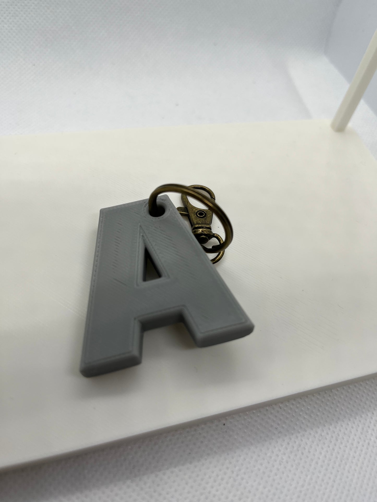 Gray letter 'A' keychain on a white surface