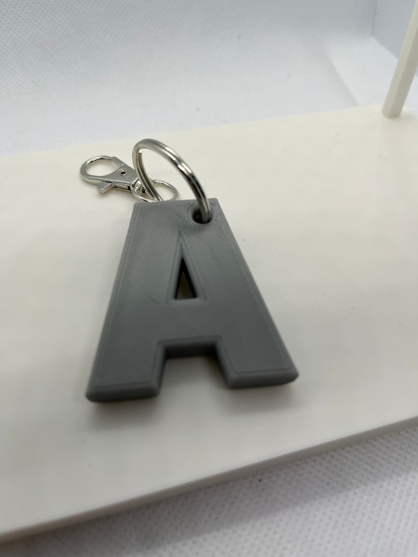 Gray keychain with a letter 'A' on a white surface