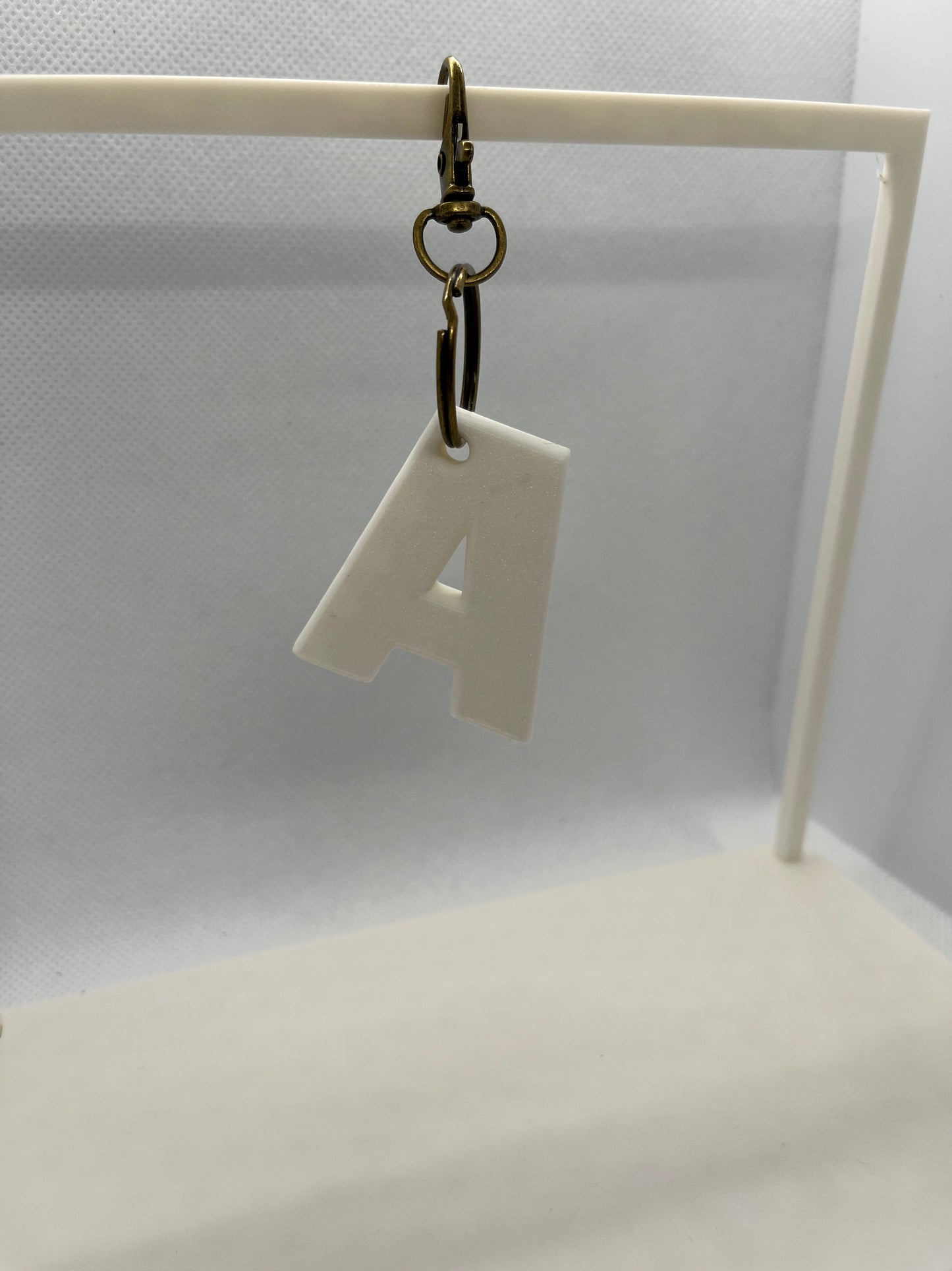 White letter 'A' keychain on a white background