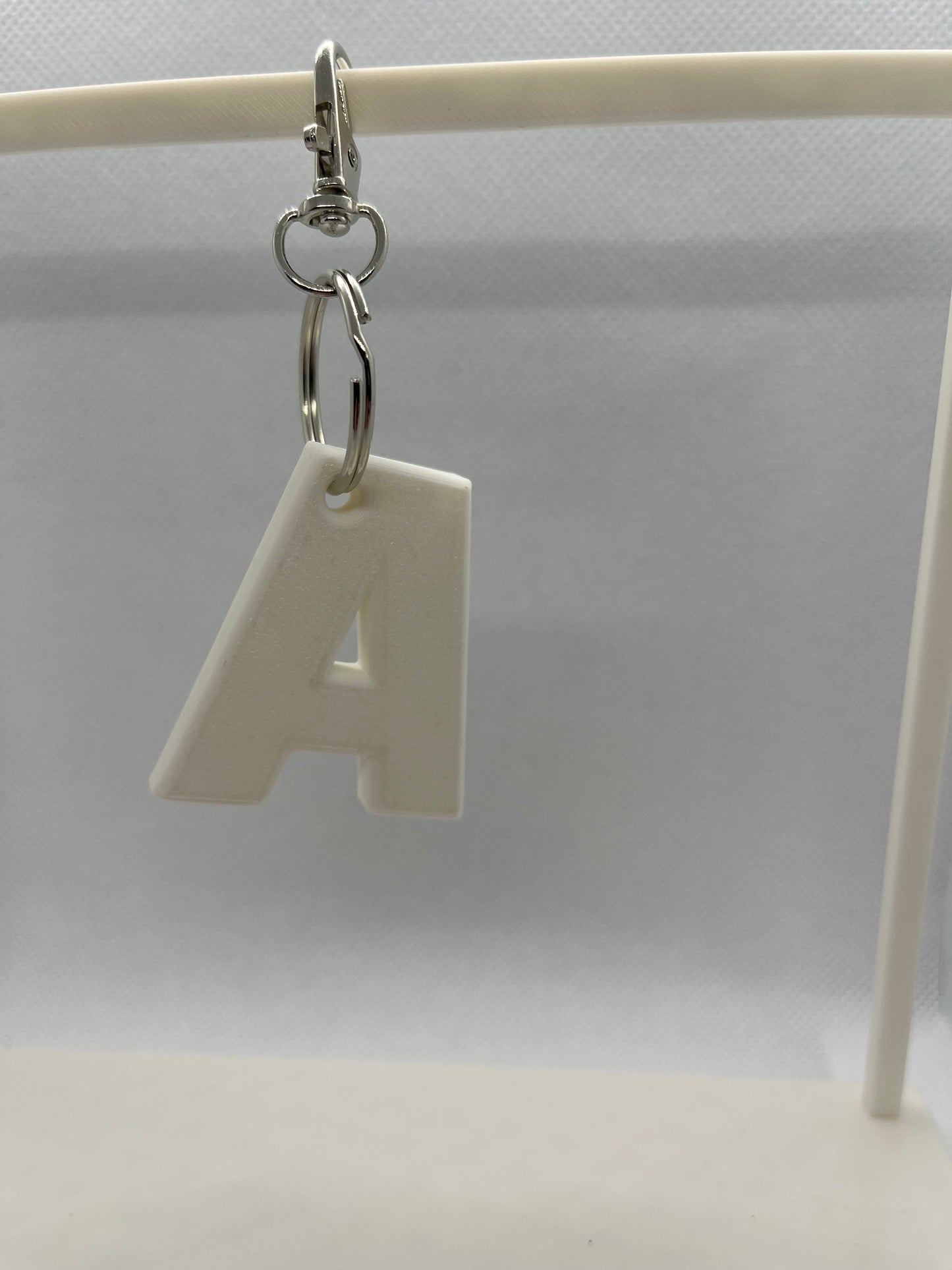 White letter 'A' keychain on a white background