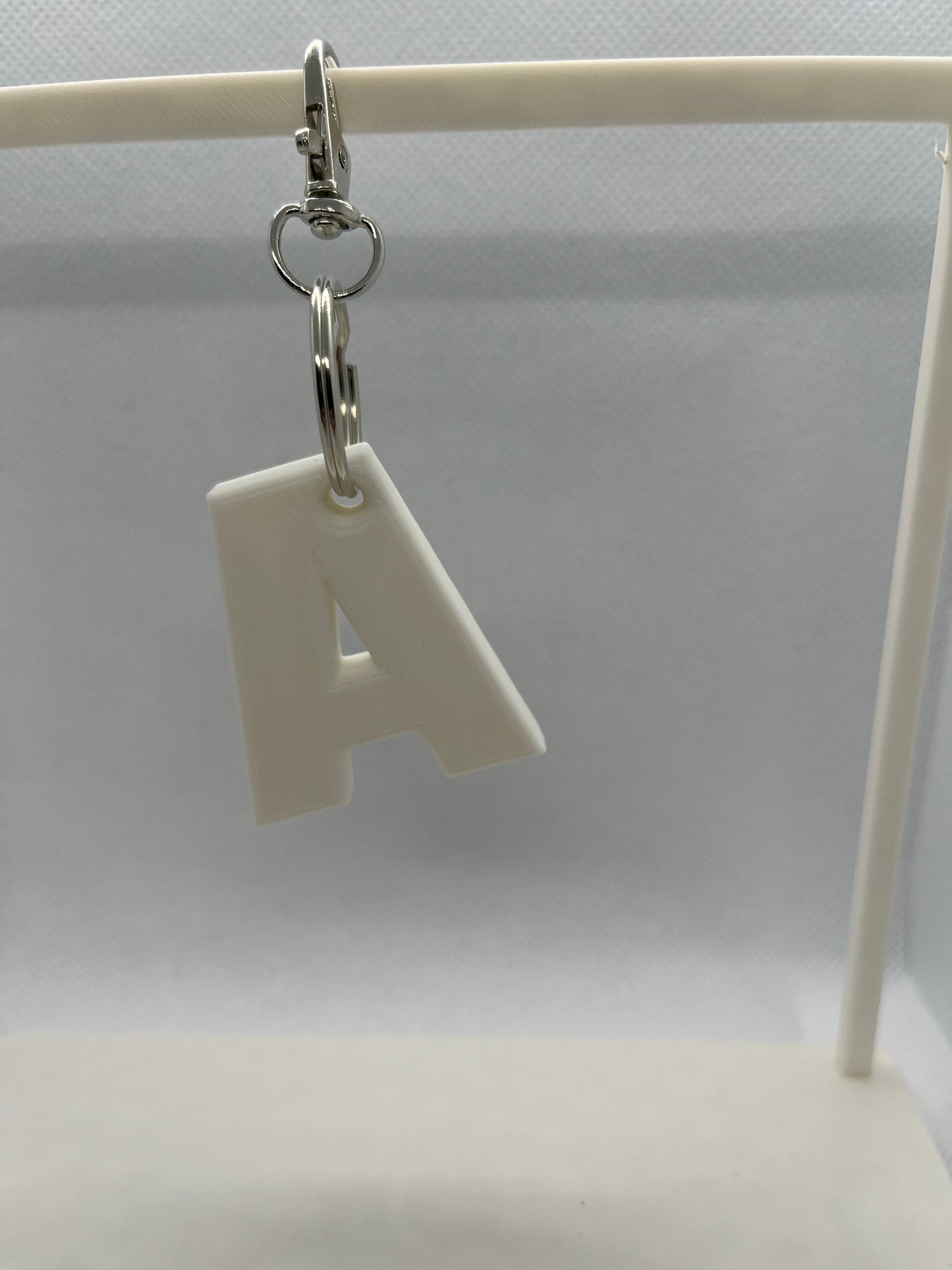 White letter 'A' keychain on a white background