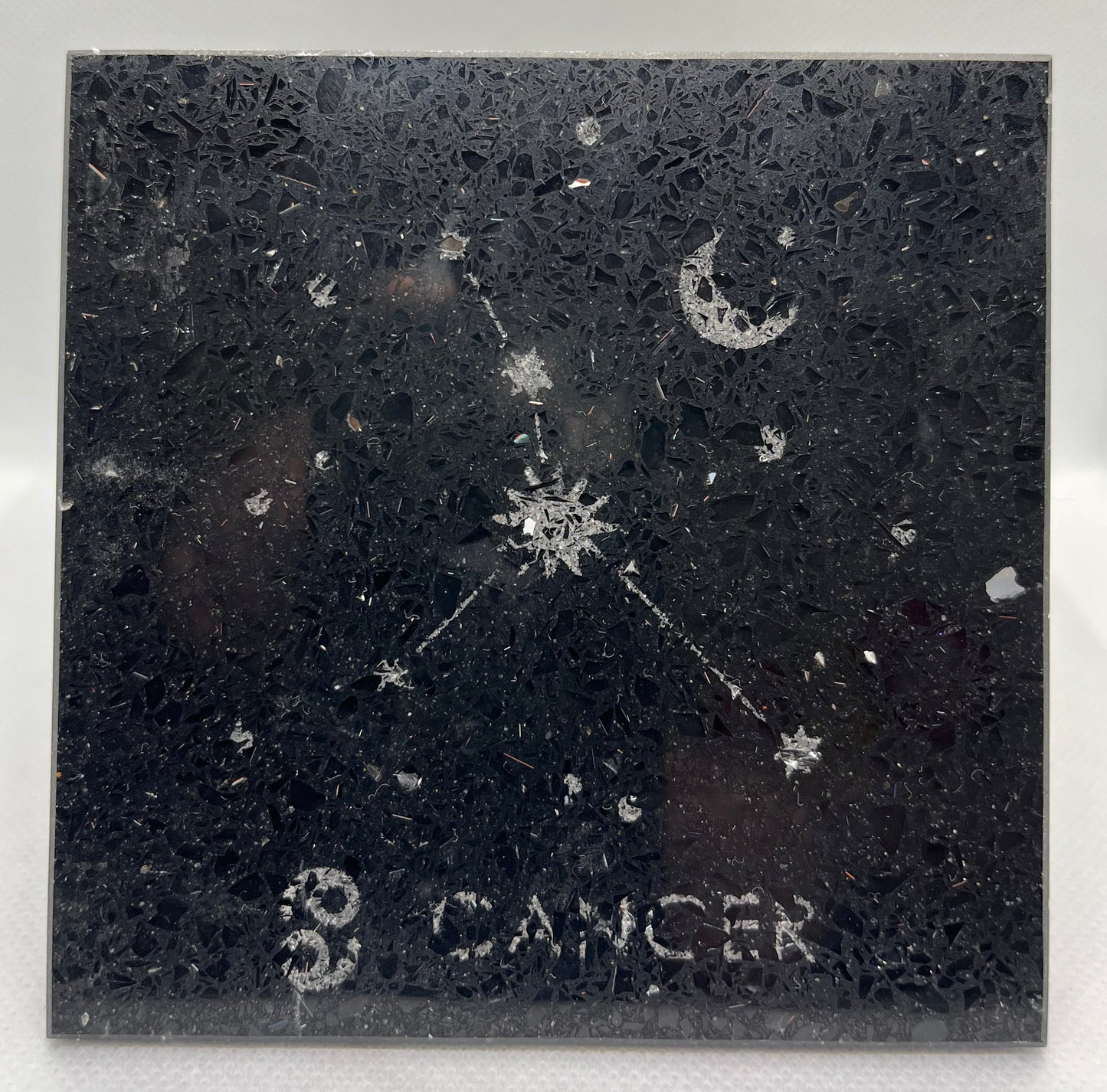 Decorative tile with zodiac sign 'Cancer' and celestial design on a black background