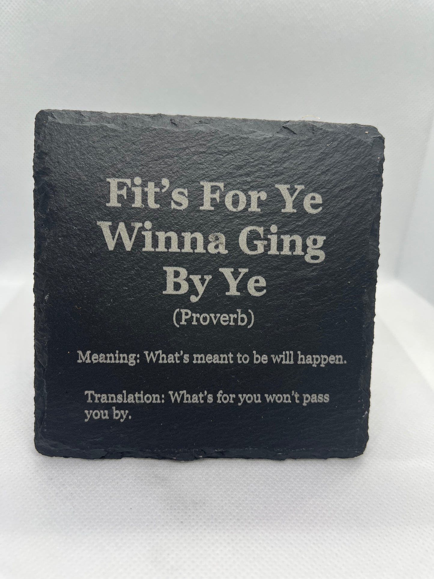 Black slate coaster with engraved text on a white background