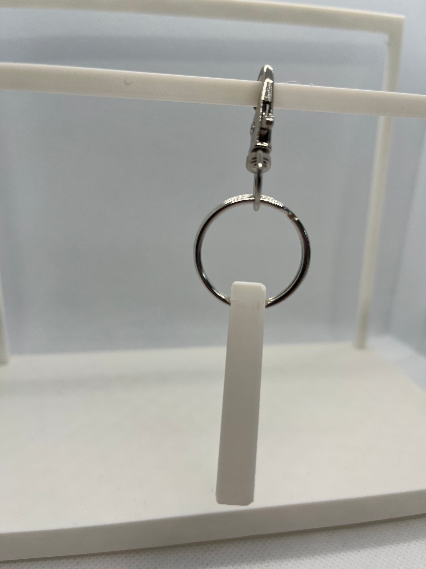 Close-up of a side image of a white keyring and metal ring on a white background