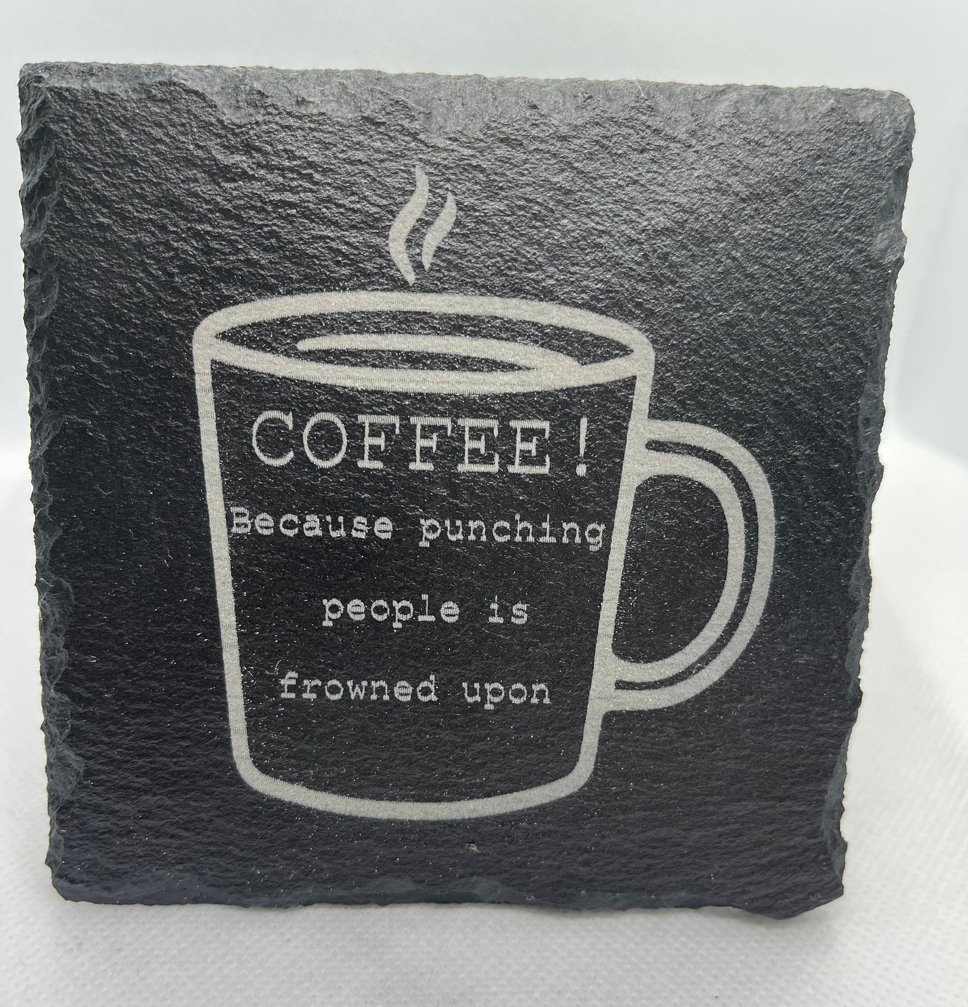 Slate coaster with coffee cup design and humorous text on a white background