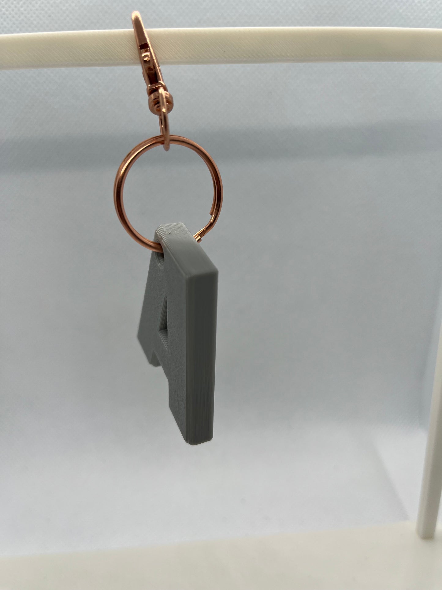 Gray A keyring with a gold ring on a white background