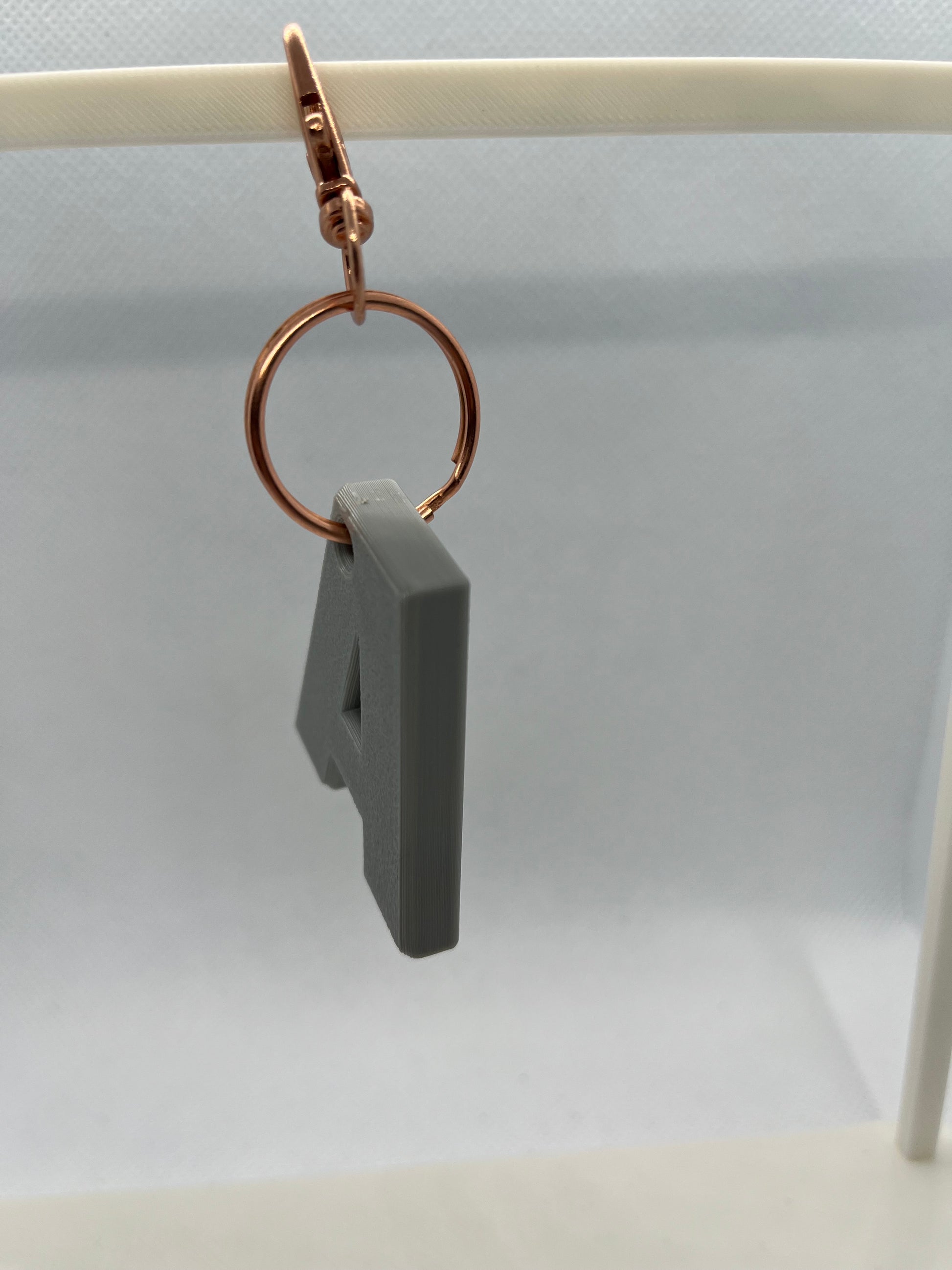 Gray A keyring with a gold ring on a white background