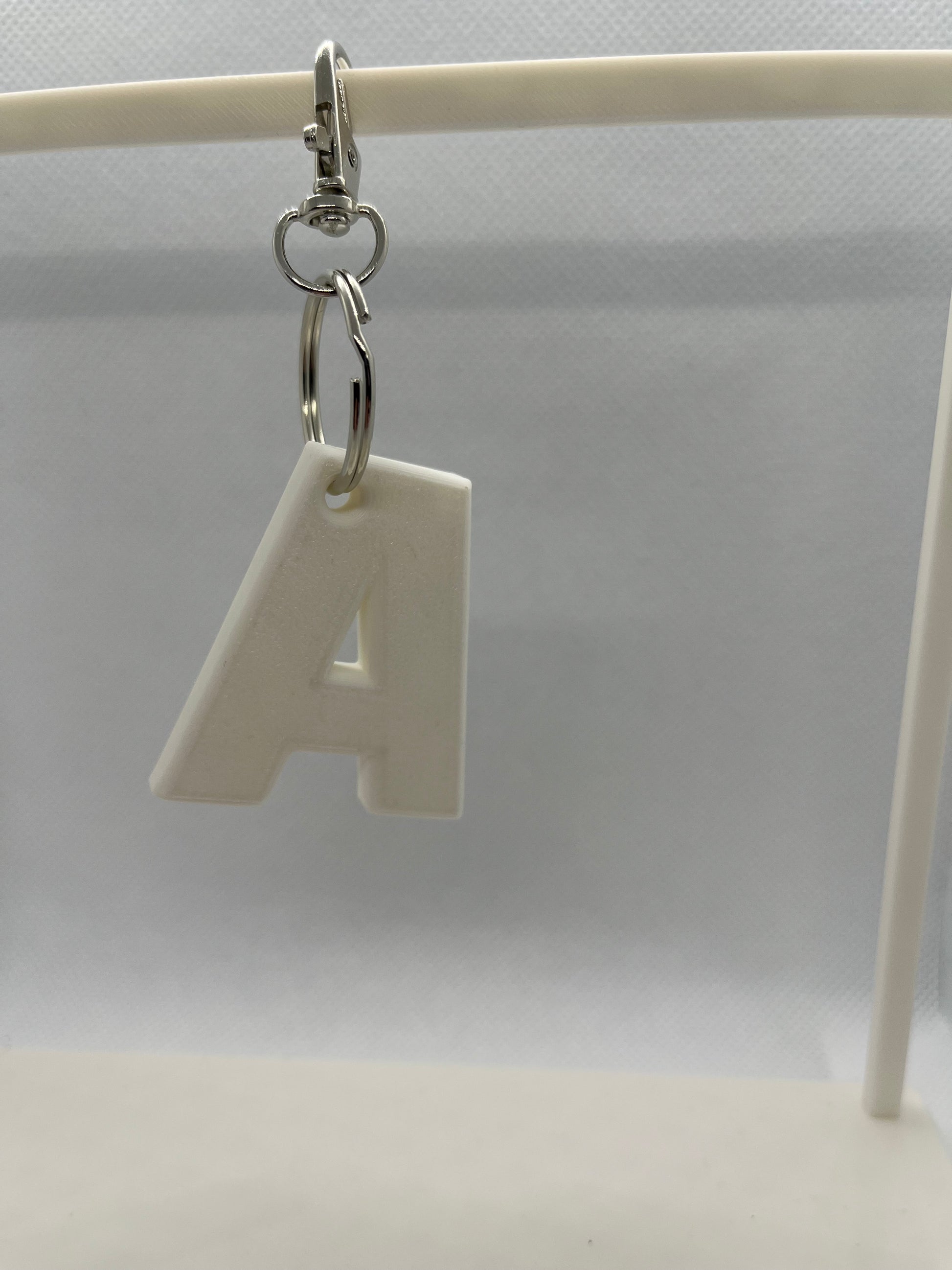 White letter 'A' keychain on a white background