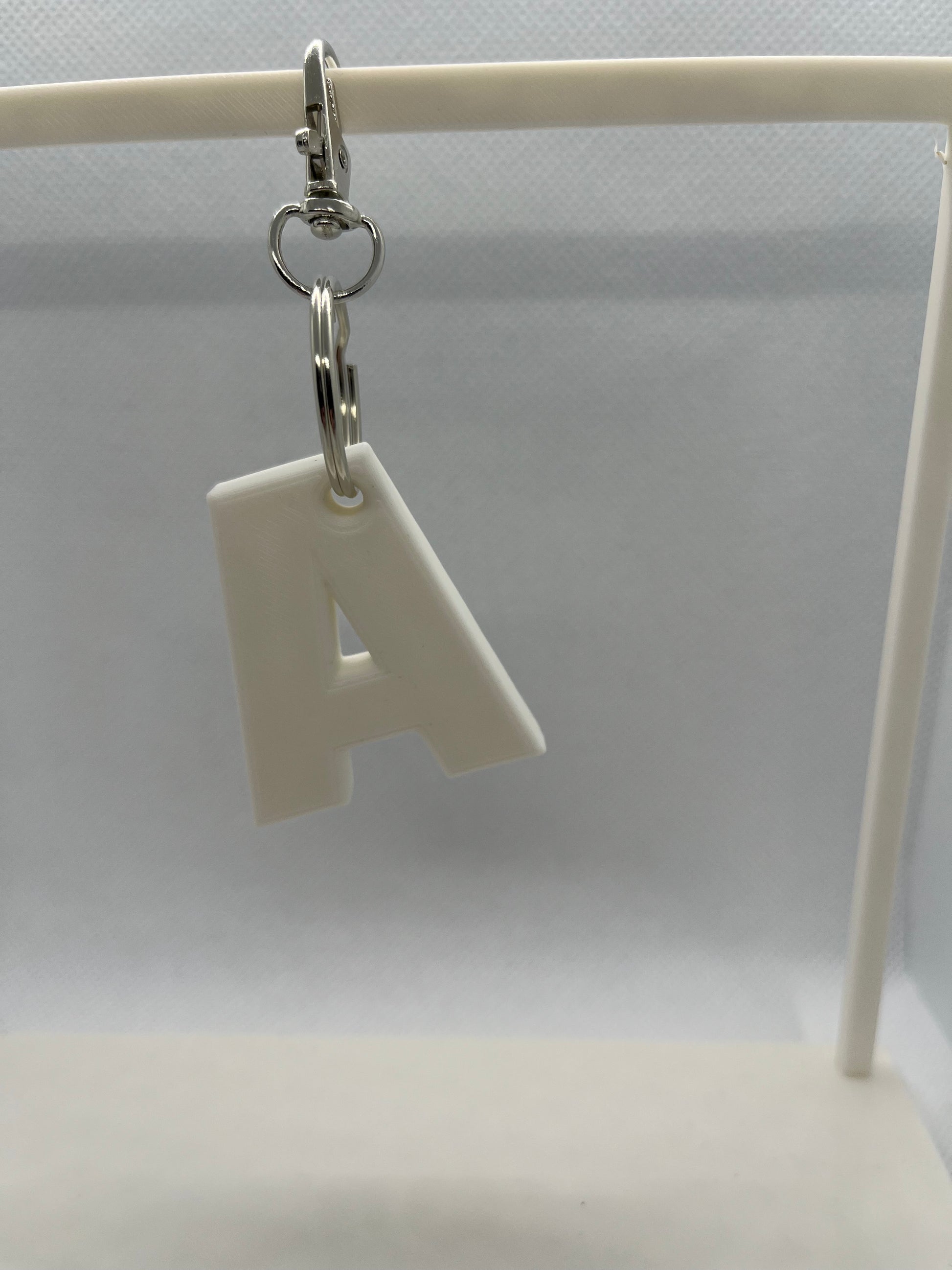 White letter 'A' keychain on a white background