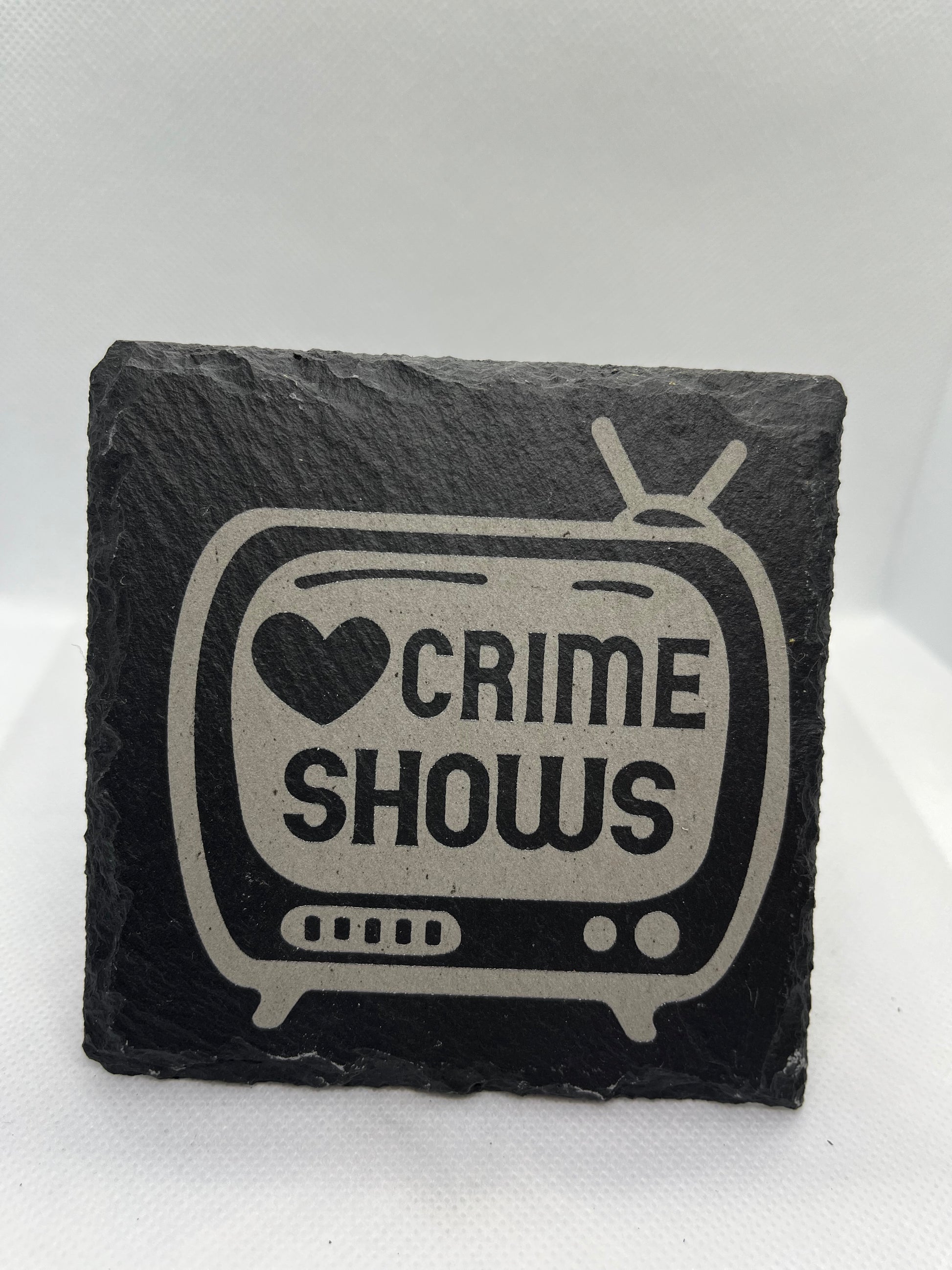 Slate coaster with 'Crime Shows' design on a white background