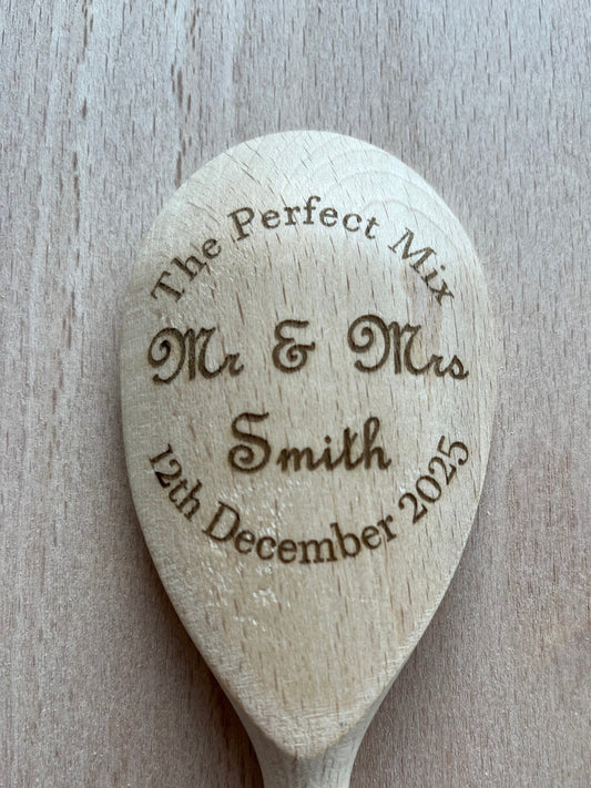 Wooden spoon with engraved text on a wooden surface