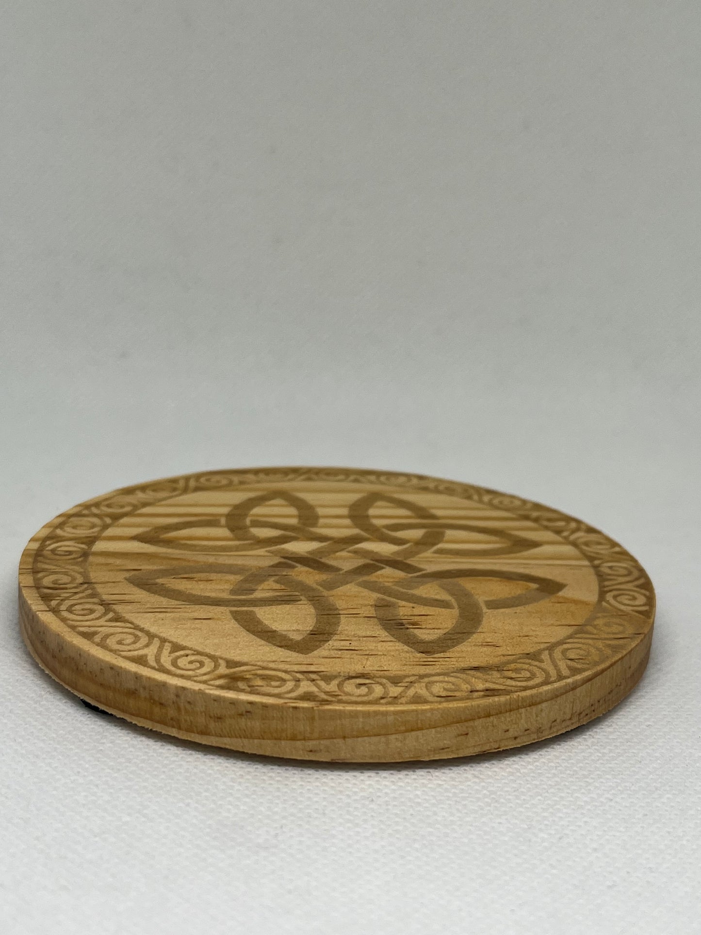 Wooden coaster with intricate carvings on a white background