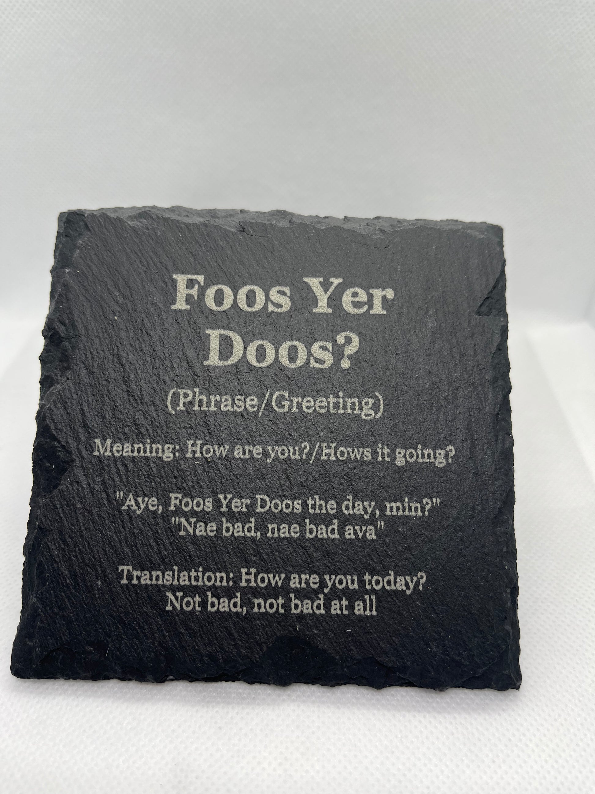 Slate coaster with Scottish phrase 'Foos Yer Doos?' and translation on a white background