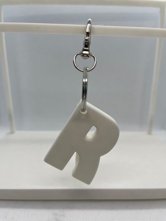 White keychain in the letter R on a white background